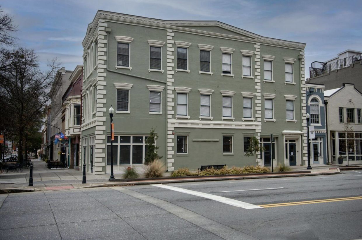 Outside view of a building with lofts on the corner of a street.