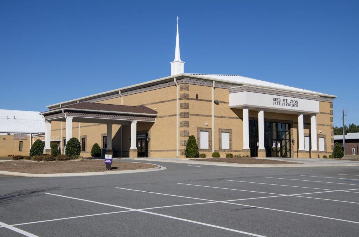 Large brick church with covered entry way, plenty of parking.