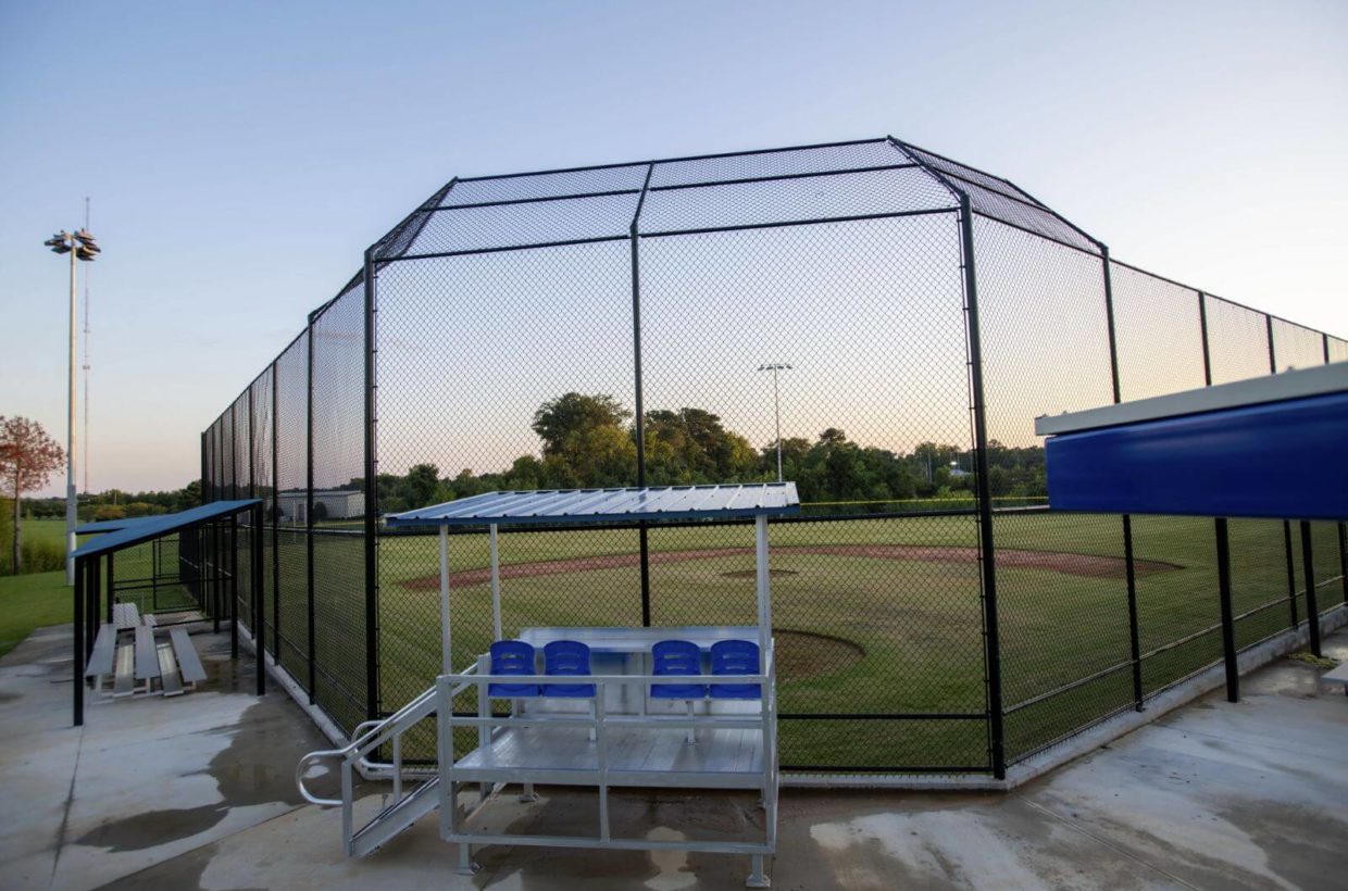 Baseball field, behind the batting area, with covered seating for the score keepers.