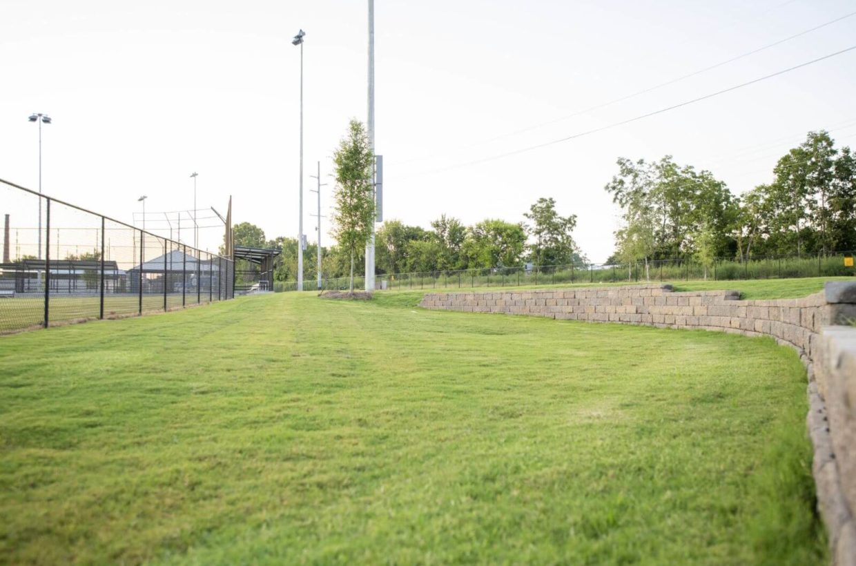 Brick and concrete walkways next to baseball fields.