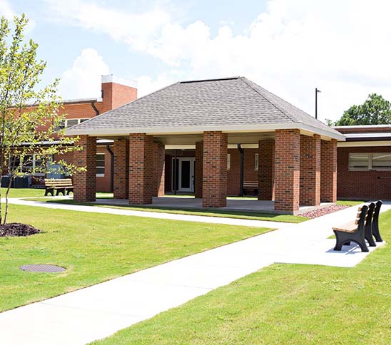 Covered brick area with concrete walkways.