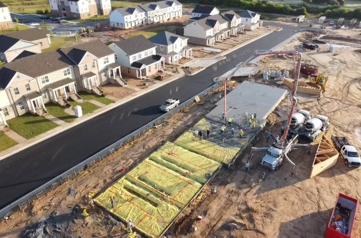 Drone view of a suburban street where the houses are under construction.