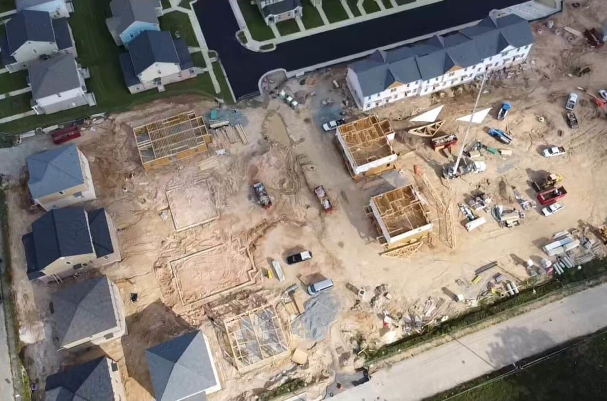 Drone view of a suburban street where the houses are under construction.